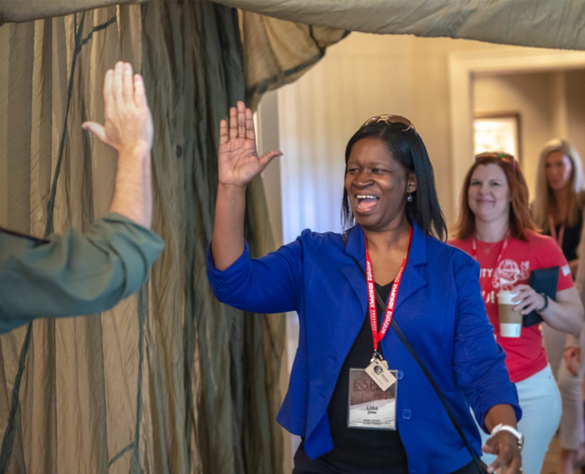 Front View Of Woman In Blue Blazer About To Give A High Five To Speaker