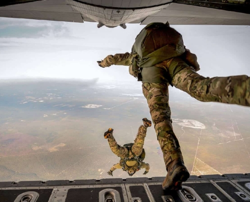 Two soldiers jumping out of an airplane