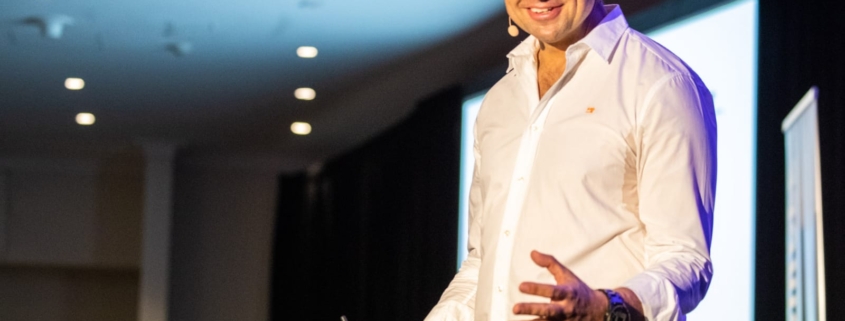 Christian Boo Boucousis speaking on stage