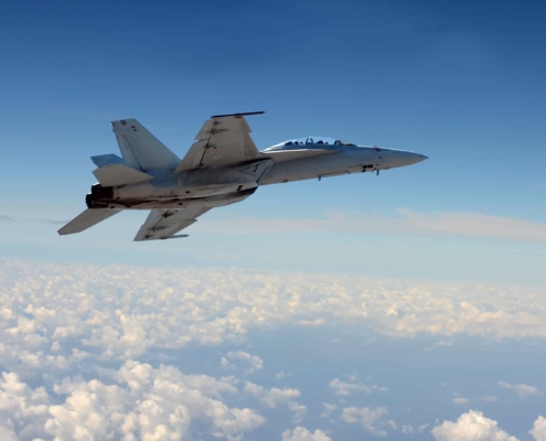 Fighter jet in partly cloudy sky