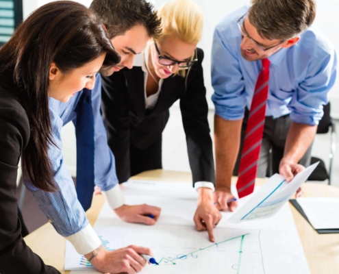 Four employees working on a graph together