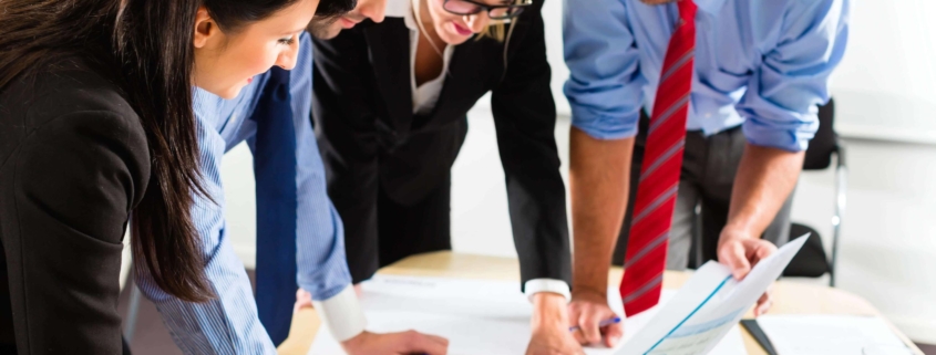 Four employees working on a graph together
