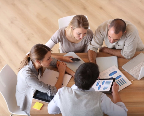 Employees huddled around table and working together