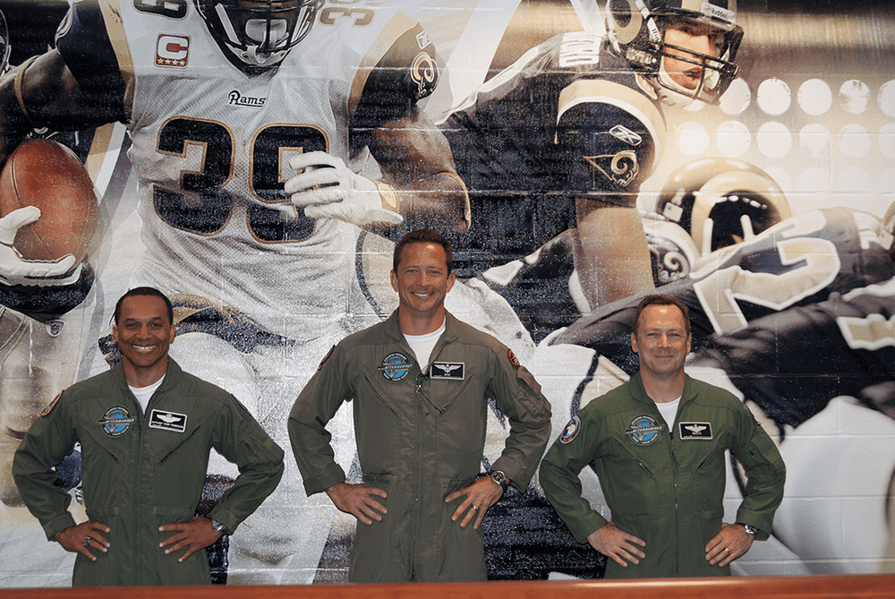 Afterburner team standing in front of St. Louis Rams mural