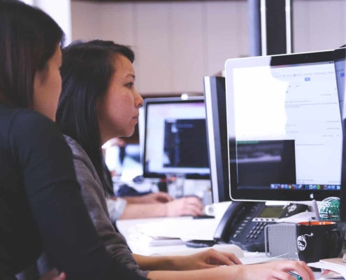 Two women staring at computer