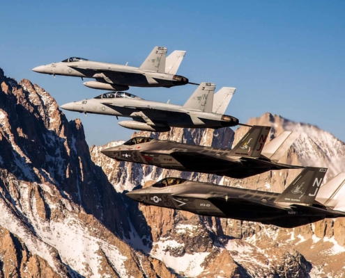 4 fighter jets flying in the mountains