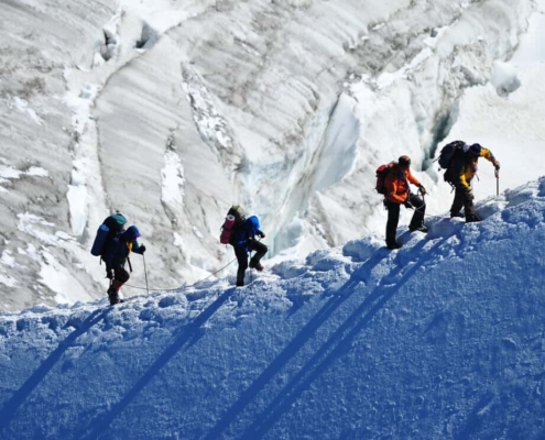 Four people climbing a mountain