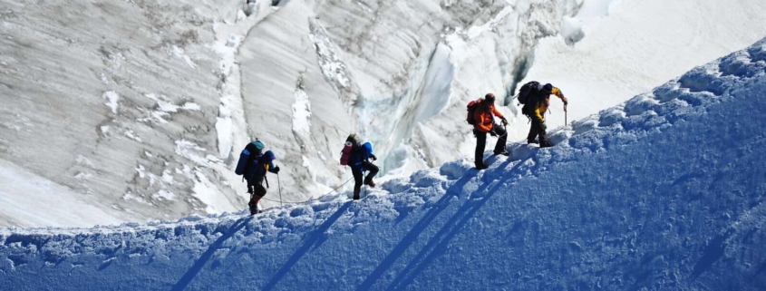Four people climbing a mountain