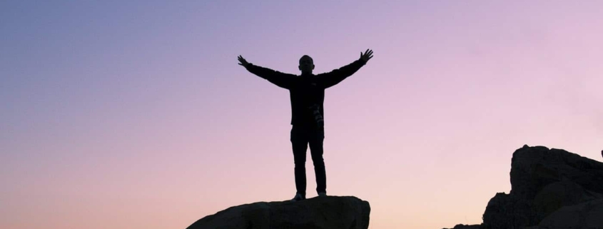 Single man standing on top of a rock