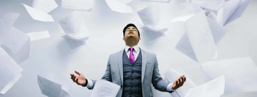 Paperwork falling on top of overworked employee