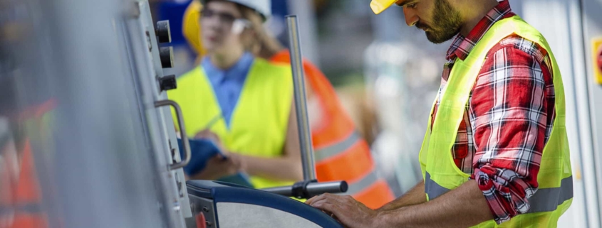 Two people in hard hats working in a factory