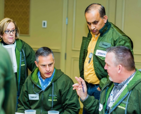 Team wearing green jackets making decisions