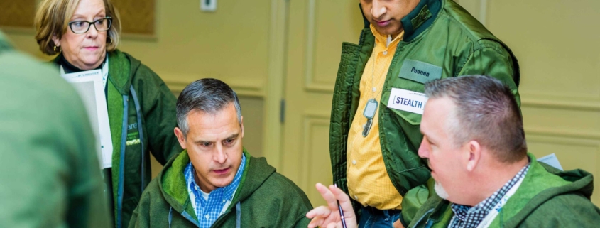 Team wearing green jackets making decisions