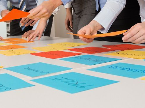 Team strategizing using note cards on table