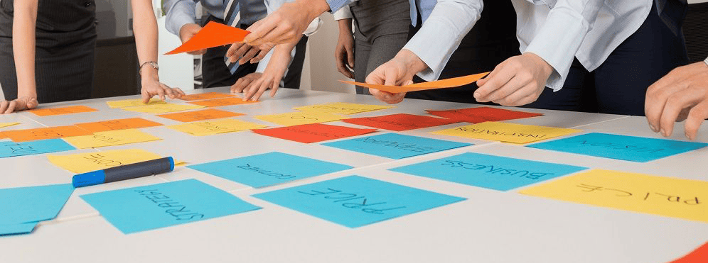 Employees using note cards to build an effective strategy