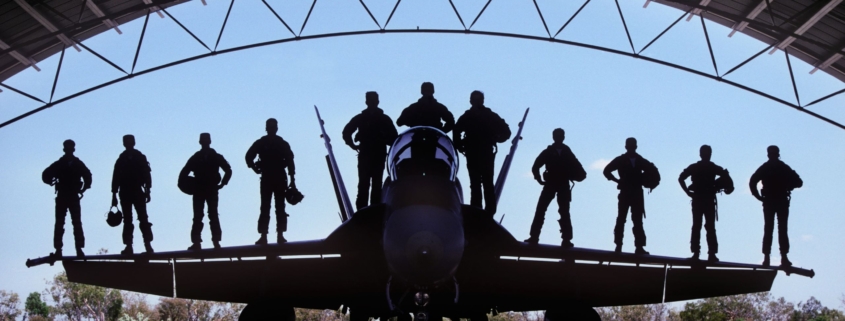 Fighter pilots standing on plane