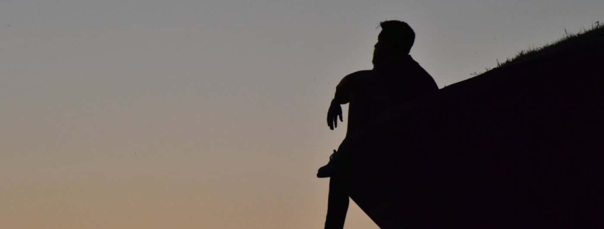 Man thinking on cliff's edge