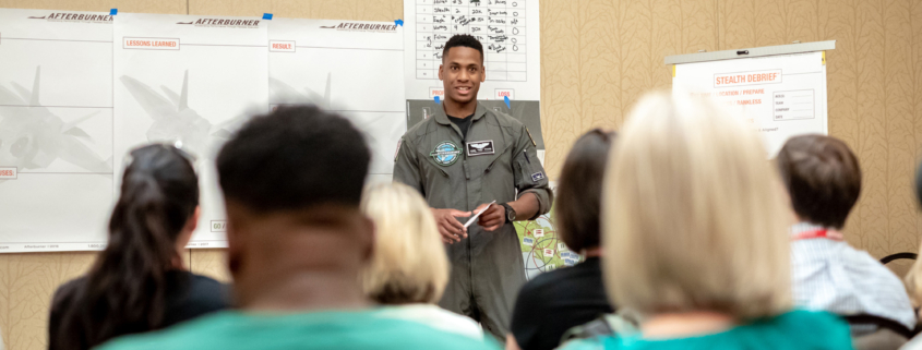 Front View Of Male Fighter Pillot Giving Presentation In Front Of Crowd