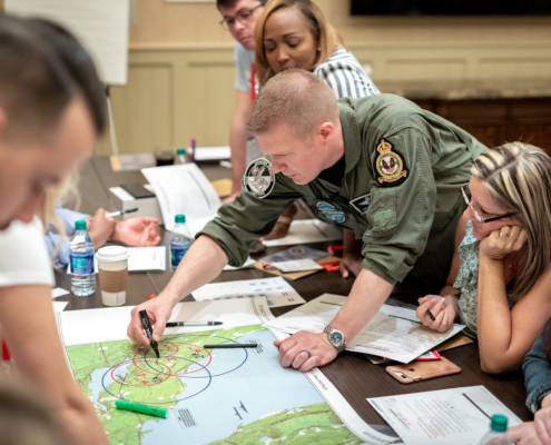 Side View Of Man Writing Something Down On Map, Strategy Meeting