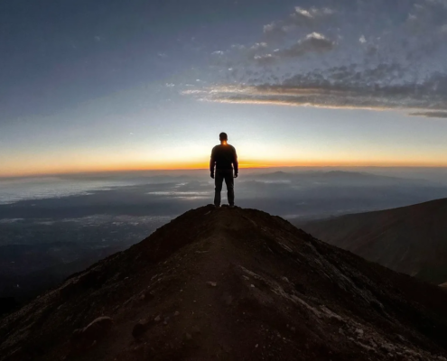 A leader reaching a mountain peak, a key goal in practical leadership development.