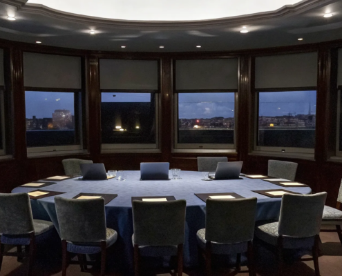 A modern boardroom prepared for a corporate debriefing training session.