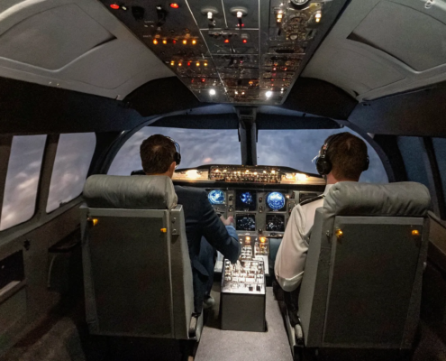 Team building leadership and decision-making skills in a flight simulator cockpit.