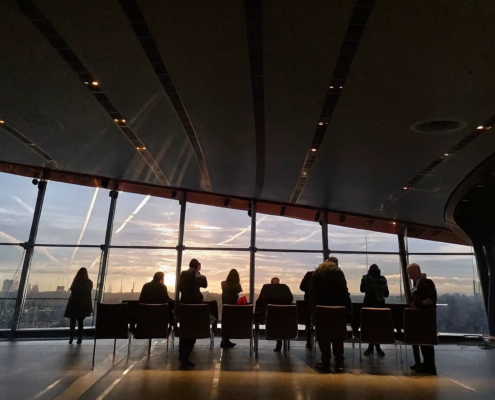 Business professionals in top gun leadership training for businesses, silhouetted at sunset.