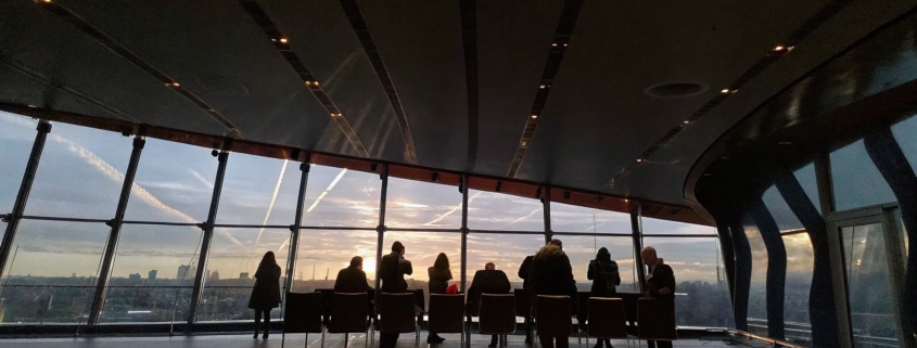 Business professionals in top gun leadership training for businesses, silhouetted at sunset.