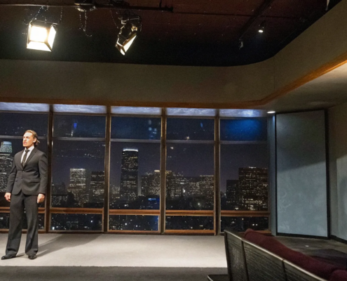 Leadership keynote speaker on stage in Los Angeles addressing a corporate audience with city skyline backdrop